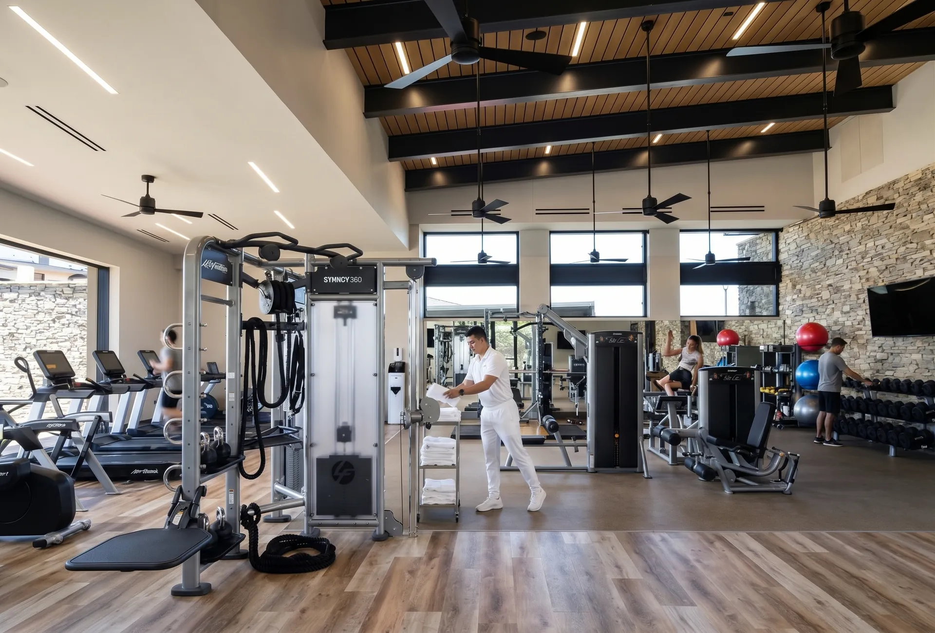 Fitness center with cardio machines, weights and a timber ceiling