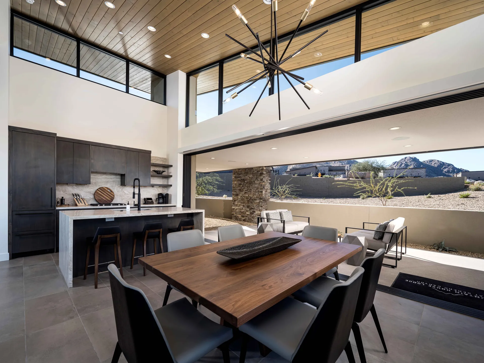 Iron Ore's dining table for six, the kitchen island and the glass wall open to the terrace