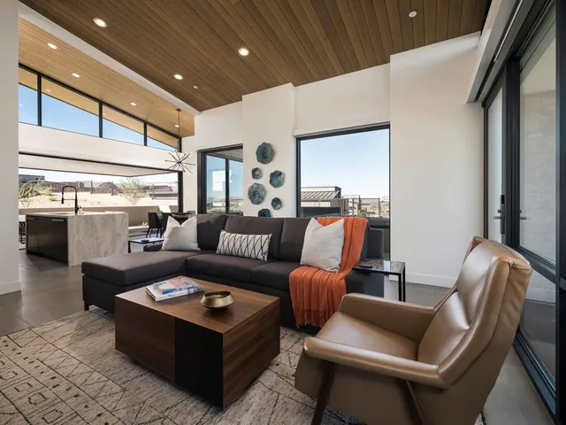Great room with a sectional, leather chair and the kitchen beyond